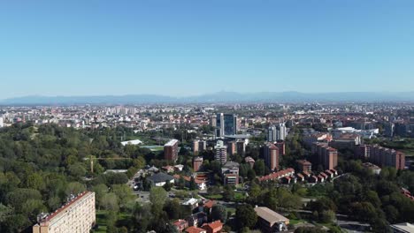 Milan-cityscape-rooftops-and-Alps-in-far-distance,-aerial-view