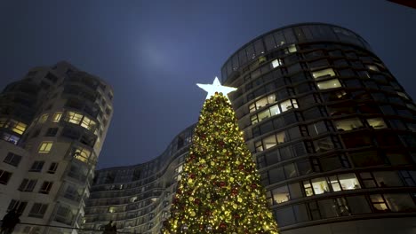 Blick-Nach-Oben-Auf-Festlich-Beleuchtete-Weihnachten-Mit-Stern-Oben-Vor-Dem-Battersea-Kraftwerk-Bei-Nacht-Mit-Gebäuden-In-Wohnungen-Im-Hintergrund
