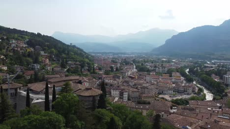 Alps-mountains-and-magical-township-of-Rovereto,-aerial-view