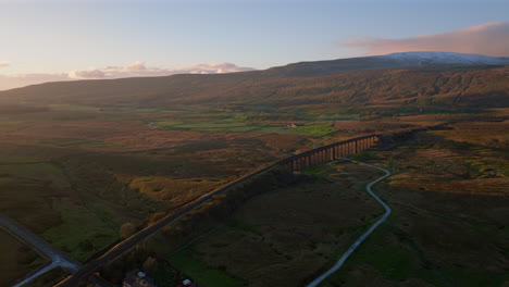High-Establishing-Aerial-Drone-Shot-of-Ribblehead-Viaduct-with-Snowy-Whernside-Mountain-Behind-in-Yorkshire-Dales-UK