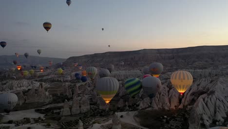 Luftaufnahme-Der-Türkei-In-Kappadokien,-Heißluftballon-Dämmerungskamera,-Die-Sich-Vorwärts-Bewegt,-Wo-Viele-Ballons-Fliegen
