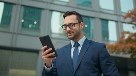 Caucasian-adult-30s-man-happy-smiling-businessman-boss-work-on-modern-smartphone-standing-outdoors-office-building-look-at-mobile-phone-chatting-online-read-message-use-banking-app-e-business-parallax
