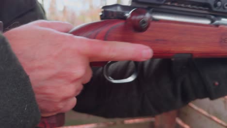 Close-up,-the-hand-of-a-hunter-loads-a-hunting-rifle
