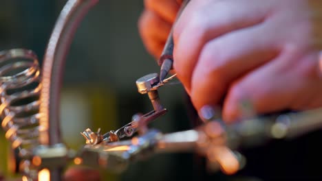 Close-up-of-the-hands-of-a-Caucasian-man-using-a-soldering-tin-iron-while-soldering-some-electrical-contacts