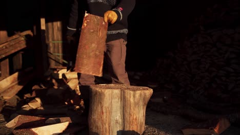 Man-Splitting-Firewood-In-Half-Using-An-Axe