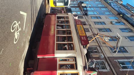 01.-Dezember-2023-Lisabon,-Portugal:-Straßenbahn-Auf-Einer-Straße-Mit-Geschmückten-Bunten-Häusern-In-Der-Weihnachtszeit