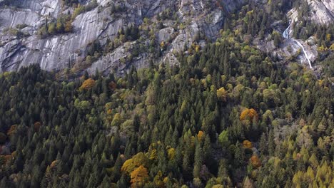 Drone-on-the-forest-in-Val-di-Mello,-ascension-from-forest-to-rocks,-Italy