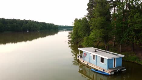 Hausboot-Schwimmt-In-Einem-Grünen-Natürlichen-See-Neben-Einem-Wald-In-Brandenburg,-Deutschland