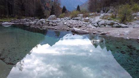 Drone-on-the-forest-in-Val-di-Mello,-on-the-river's-reflections,-Italy