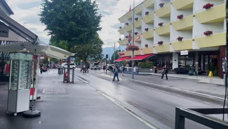 Interlaken-Switzerland-Immersive-Travel-Tourism-Mountainside-Valley-Resort-City,-Europe,-Walking,-Rainy-Day,-4K-|-Looking-Around,-Shaky,-Water,-River,-Lake,-Restaurant,-Crowd,-Cafe,-Street