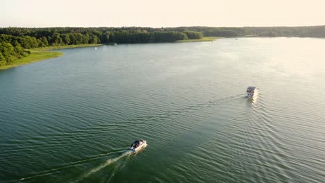 Zwei-Motorboote-Fahren-Bei-Sonnenuntergang-Auf-Einem-Großen-Natürlichen-See-In-Brandenburg,-Deutschland