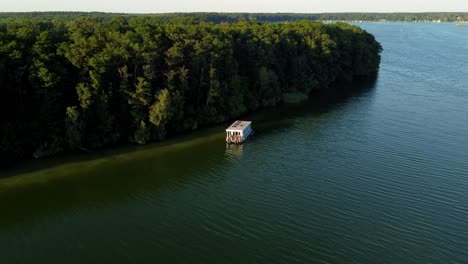 House-boat-floating-on-a-lake-during-sunrise-in-Brandenburg,-Germany