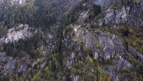 Drone-En-El-Bosque-En-Val-Di-Mello,-Deslizándose-Sobre-Rocas,-Italia