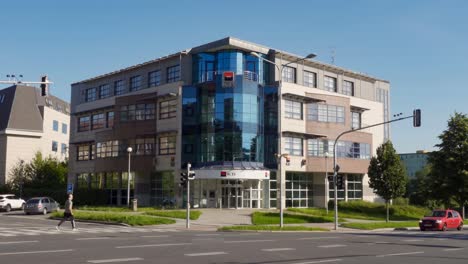 Oficina-Del-Banco-Checo-Komercni-Banka-En-Havirov-Con-Coches-Y-Peatones-Cruzando-La-Calle