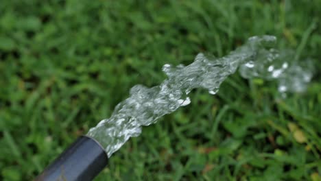 Notwendiges-Wasser-Spritzt-Aus-Einem-Rohr-über-Das-Gras-Eines-Gartens