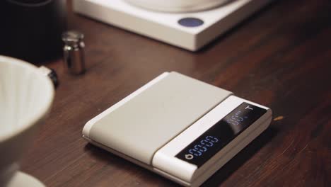 Barista-put-ceramic-cup-on-scales-and-push-tare-button-to-zero-out-weight