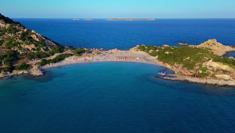 Aerial-drone-backward-moving-shot-over-tourists-sunbathing-on-breathtaking-Punta-Molentis-Beach,-Villasimius,-South-Sardinia,-Italy-on-a-sunny-day