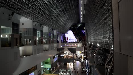 Kyoto-Moderner-Architektonischer-Bahnhof-Bei-Nacht,-Fußgänger-Bewegen-Sich-In-Richtung-Bahnsteige