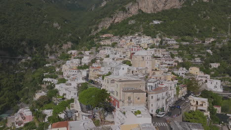 Luftaufnahmen-Der-Gebäude-Auf-Den-Hügeln-Oberhalb-Von-Positano,-Die-Auf-Eine-Kirche-Zufliegen