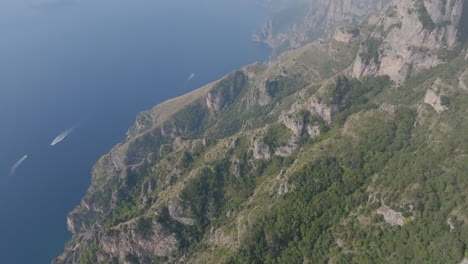 Aerial-footage-of-the-mountains-and-cliffs-off-the-Amalfi-Coast-with-boast-in-the-Meditteranean-Sea