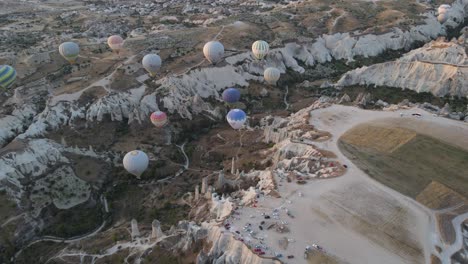 Drone-view-of-balloons-flying-in-the-morning-at-very-popular-tourist-entertainment-center-in-Cappadocia,-Turkey