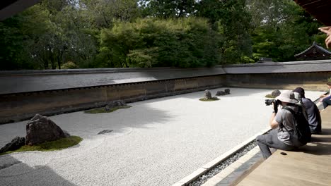 Photographer-shooting-touristic-attraction-zen-rock-garden-Ryoanji-Temple-in-Kyoto-Japan
