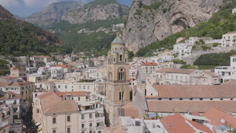 Slow-aerial-move-and-pan-up-towards-the-church-tower-of-Duomo-di-Amalfi-in-Amalfi,-Italy