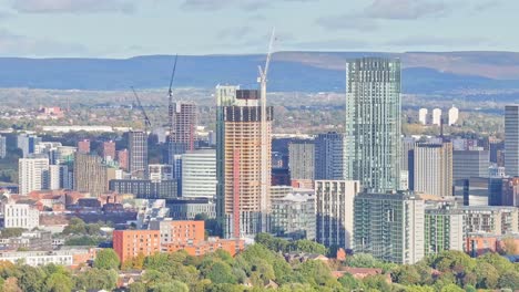 Trucking-zoomed-drone-shot-of-the-high-buildings-in-the-skyline-of-Manchester-on-a-sunny-day