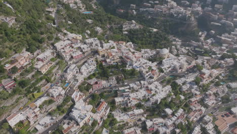 Aerial-footage-panning-up-over-the-hills-and-cliffs-of-the-Amalfi-Coast-over-the-town-of-Positano,-Italy