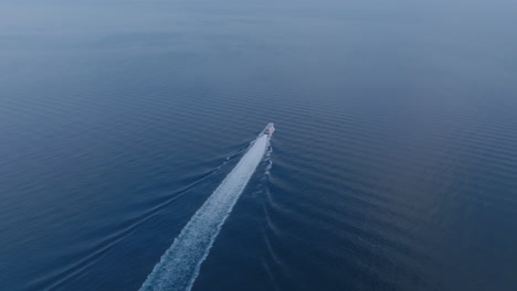 Aerial-footage-following-a-speed-boat-that-is-traveling-away-from-Sorrento-towards-Naples,-Italy