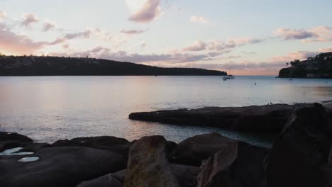 Timelapse-of-Sydney-Bay-at-dawn-with-boats-and-clouds-moving,-all-turning-from-dark-into-light-as-the-day-approaches,