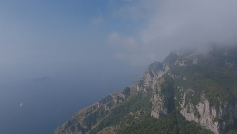 Wide-aerial-footage-pulling-back-from-the-mountains-above-the-Amalfi-Coast-that-are-covered-in-clouds-in-the-late-morning-in-Italy
