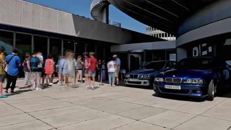 Line-of-people-enter-BMW-museum-for-50-years-celebration,-time-lapse