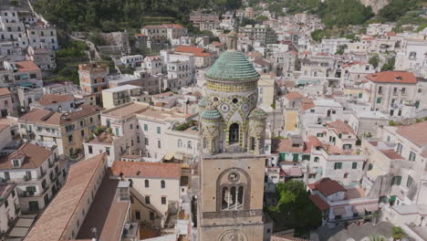 Rotating-aerial-footage-flying-up-around-from-the-spire-of-a-church,-the-Duomo-di-Amalfi-in-Amalfi