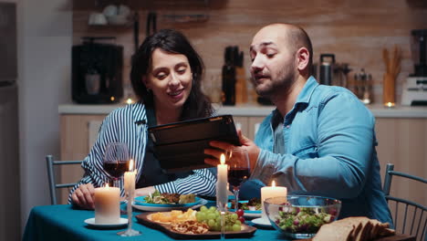 Husband-using-tablet-during-festive-meal