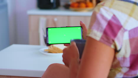 Frau-Beobachtet-Ein-Telefon-Mit-Grünem-Bildschirm
