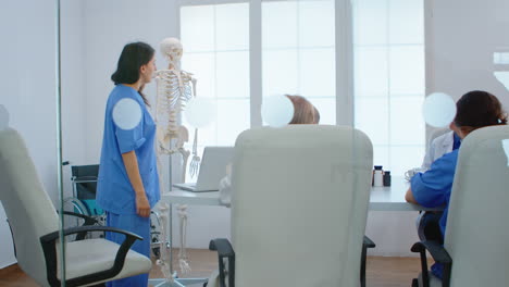 Enfermera-Médica-Apuntando-A-La-Columna-Cervical-Del-Esqueleto-Humano