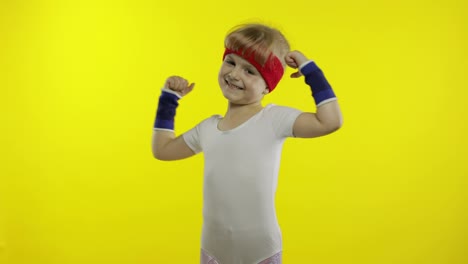 Athletisches-Mädchen-In-Weißer-Sportkleidung,-Das-Isolierte-Muskeln-Auf-Gelbem-Hintergrund-Zeigt.-Training-Für-Kinder