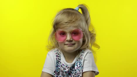 Kind-Lächelt-Und-Blickt-In-Die-Kamera.-Touristin-Mit-Rosa-Sonnenbrille-Posiert-Auf-Gelbem-Hintergrund