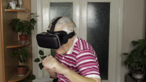 Großmutter-Mit-Virtueller-Headset-Brille,-Die-Sich-Ein-Video-In-Der-Trainingsbox-Mit-VR-Helm-Ansieht,-Zeigt-Faustkampf
