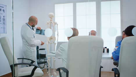 Physician-learning-colleagues-body-bone-functionson-using-x-ray-and-human-skeleton