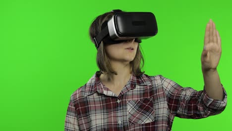 Young-woman-using-VR-headset-helmet-to-play-game.-Watching-virtual-reality-3d-360-video.-Chroma-key