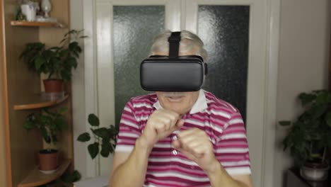 Grandmother-in-virtual-headset-glasses-watching-video-in-VR-helmet-training-box,-shows-fist-fight