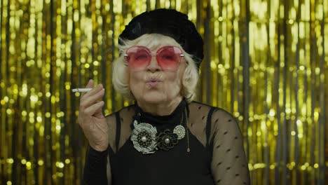 Elderly-style-mature-grandmother-in-fashion-black-clothes-in-sunglasses-posing,-smoke-cigarette