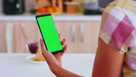 Woman-looking-at-phone-with-green-touchscreen