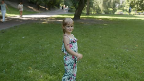 Portrait-of-little-girl-smiling.-Child-having-fun-in-park.-Childhood.-Jumping,-fighting,-dancing