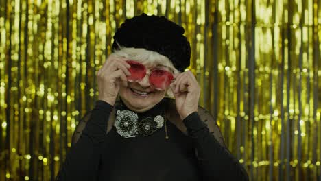 Schöne-ältere-Frau,-Die-Eine-Rote-Sonnenbrille-Berührt-Und-Spielerisch-Zwinkert,-Flirtet-Und-Mit-Den-Augen-Blinzelt