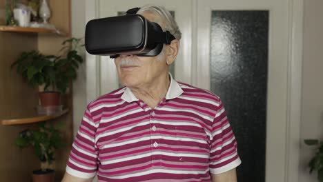 Älterer-Großvater-Mit-Virtueller-Headset-Brille,-Der-Sich-Zu-Hause-3D-Videos-Im-360-VR-Helm-Ansieht