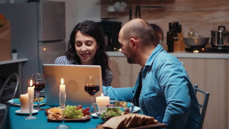 Couple-using-laptop-during-dinner