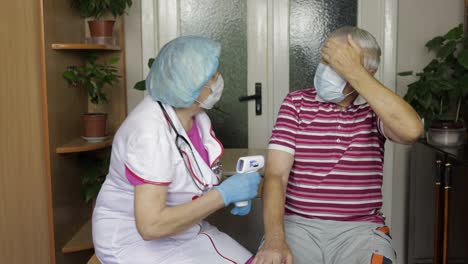 Krankenschwester-Misst-Die-Temperatur-Mit-Einem-Berührungslosen-Elektronischen-Thermometer-Des-Kranken-Großvaters.-Coronavirus